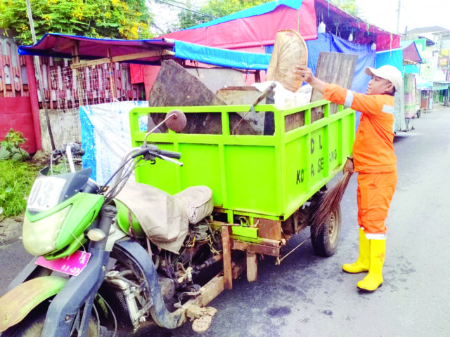 ANGKUT SAMPAH: Petugas kebersihan DLH Kota Serang Abdul Gani mengendarai cator mengangkut sampah di ruas Jalan Juhdi, Pasar Royal, Kota Serang, Kamis (5 Desember 2024).