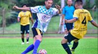 Kapolres Cilegon AKBP Kemas Indra Natanegara menggiring bola dibayangi pemain dari tim wartawan.